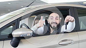 Visiting car dealership. Beautiful family is talking and smiling while sitting in their new car . young man shows finger