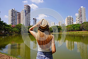 Visiting Goiania, Brazil. Back view of young woman in Parque Sulivan Silvestre also known as Parque Vaca Brava, a city park in photo