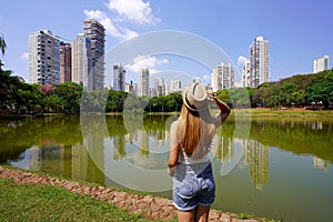 Visiting Goiania, Brazil. Rear view of beautiful girl in Parque Sulivan Silvestre also known as Parque Vaca Brava, a city park in photo