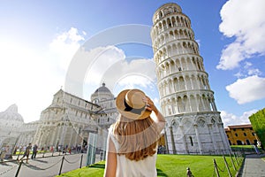 Visiting the Leaning Tower of Pisa, famous landmark of Italy. Young traveler woman in Piazza del Duomo square in Pisa, Tuscany,