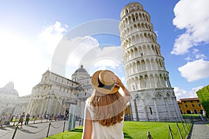 Visiting the Leaning Tower of Pisa, famous landmark of Italy. Young traveler woman in Piazza del Duomo square in Pisa, Tuscany, photo