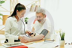 The visiting nurse taking care of senior man