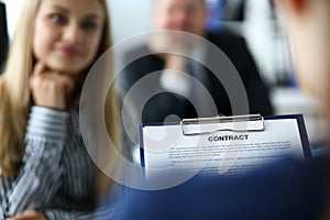 Visitor examining contract application form clipped to pad