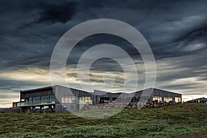 Visitor Gullfoss tourist centre with brandname shop, restaurant, souvenir and information service with dramatic sky on gloomy day