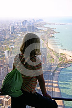 A visitors looking out of the former Hancock Tower in Chicago, Illinois