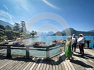 visitors of lake annecy on boardwalk talloires