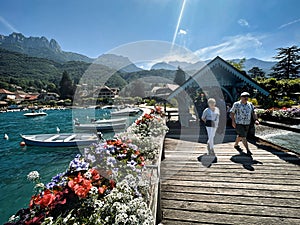 visitors of lake annecy on boardwalk talloires