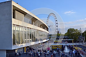 Visitors outside the Royal Festival Hall in with London Eye in t