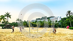 Visitors playing volleyball at Siloso Beach, Sentosa Island, Singapore.