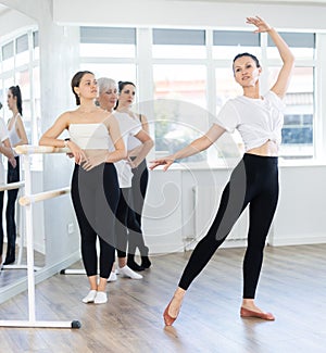 Visitors to choreographic class, observe professional rendering of dance elements performances couch