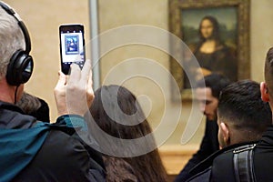 Visitors view and photograph the Mona Lisa