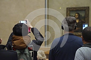 Visitors view and photograph the Mona Lisa