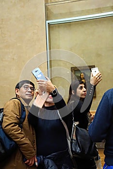 Visitors view and photograph the Mona Lisa