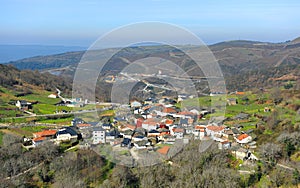 Vista panorÃÂ¡mica del pequeÃÂ±o pueblo de Cerdedelo entre montaÃÂ±as al comienzo de la primavera photo