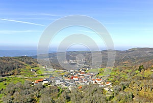 Vista panorÃÂ¡mica del pequeÃÂ±o pueblo de Cerdedelo entre montaÃÂ±as al comienzo de la primavera photo