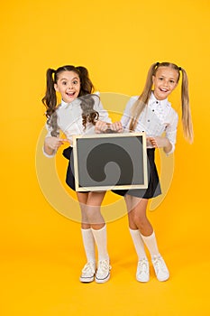 Visual communication. Girls school uniform hold blackboard. Back to school concept. Upcoming events in school. Glad to