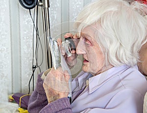 Visually impaired elderly woman with magnifyer photo