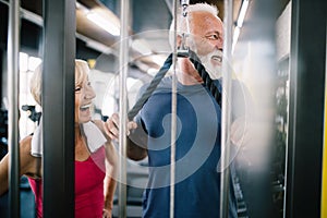 Vital mature couple exercising in the gym.