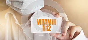 Vitamin B12 written on a card in doctors hands. Medical healthcare concept