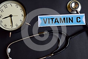 Vitamin C on the paper with Healthcare Concept Inspiration. alarm clock, Black stethoscope.