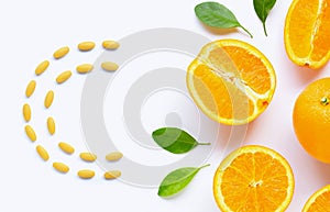 Vitamin C pills with  fresh orange citrus fruit isolated on white