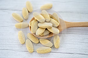 Vitamin C pills on wooden spoon for good health