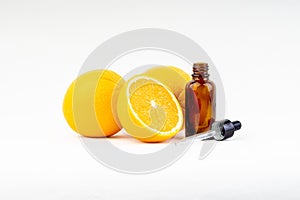 Vitamin C serum bottle with dropper and orange on white background.