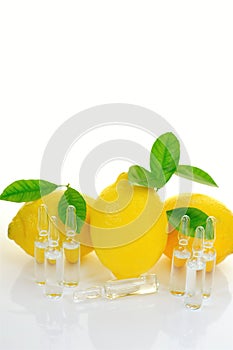 Vitamin C.Serum with Vitamin C. Transparent ampoules set, lemons fruits with green leaves on a white background with