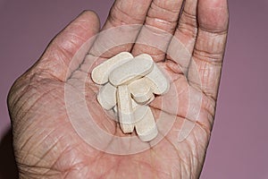 Close up picture of a man hand holding Vitamin C pills, 1000mg.