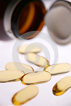 Vitamin capsule gold colour isolated white background