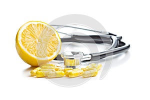 Vitamin capsules. Vitamin C pills, stethoscope and yellow lemon photo