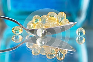 Vitamin D supplement pills close up or macro view in a spoon suggesting choosing a natural alternative to lower the risk of illnes