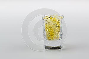 Vitamin E Pills Capsules White Background in shot glass tight view close crop