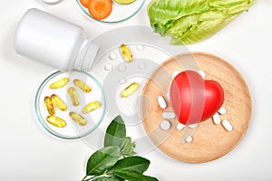 Vitamin nutrition pills and heart model, Natural medicine supplement from organic fresh fruit and vegetable