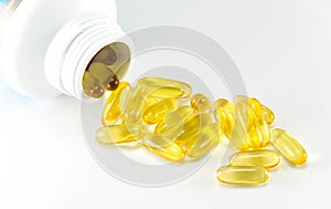 Vitamin Omega-3 fish oil capsules near a bottle