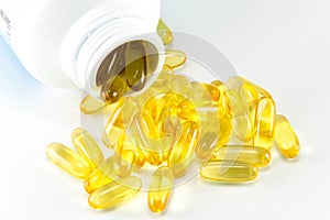 Vitamin Omega-3 fish oil capsules near a bottle