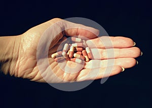 Vitamin OTC capsules on a sunlit hand