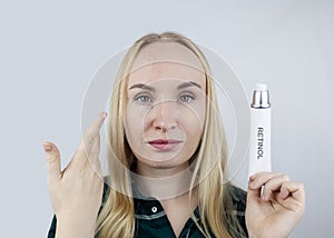 Vitamin A, Retinol, Niacinamide, Vitamin C. Girl smears her face with antioxidant anti-wrinkle cream