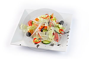 Vitamin salad with fresh vegetables on a white plate on white background, closeup