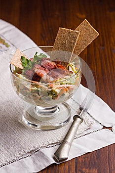 Vitamin salad made of grated carrot and cabbage in white dip, covered with baked, crispy bacon and crunchy thins with flax seed.