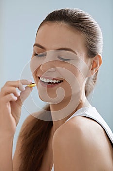 Vitamin. Smiling woman taking omega pill, fish oil supplement