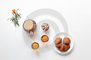 Vitamin tea with herbs and sea buckthorn, cereal gluten-free cookies with dried fruits on a wooden board. Healthy food, tea drink
