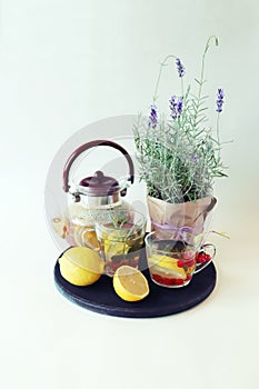 Vitamin tea made from berries, healthy herbs, lemon in glass cups and a teapot