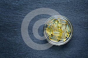 Vitamine D gel capsules on dark background