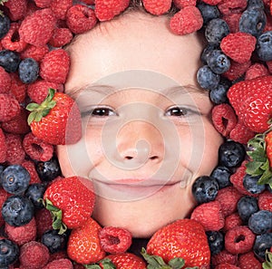 Vitamins from berrie. Child face with berry frame, close up. Berries mix blueberry, raspberry, strawberry, blackberry