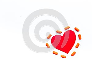 Vitamins of drugs for heart. Color pills near heart sign on white background top view copy space