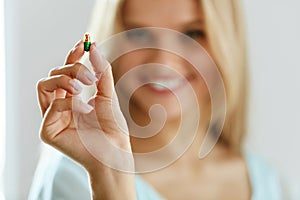 Vitamins And Food Supplements. Beautiful Woman With Pill In Hand