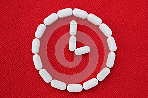 Vitamins and generics, pharmacy and medicine concept. Watch from white pills on a red background. Top view, place for text. Medici