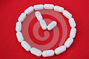 Vitamins and generics, pharmacy and medicine concept. Watch from white pills on a red background. Top view, place for text. Medici