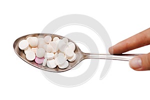 Vitamins and pills on a spoon, medicines are on the white background